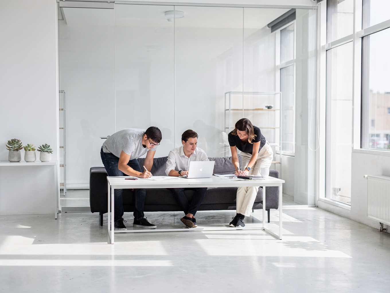 Industrial co-working space with exposed ceiling trusses and warm pendant lighting