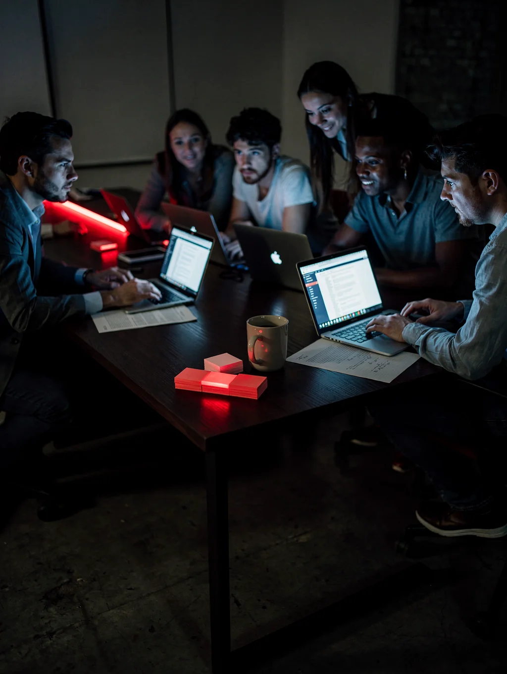 People conversing in an intimate, moody urban studio illuminated by warm evening side light